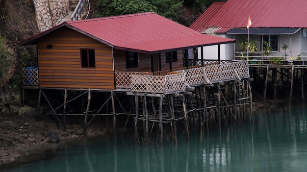 Villaggio galleggiante in legno sul bordo del fiume con acqua blu