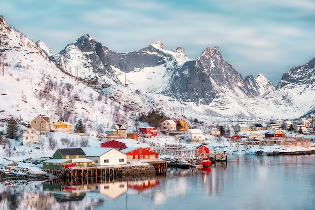 Villaggio scandinavo colorato con la montagna di neve sulla costa
