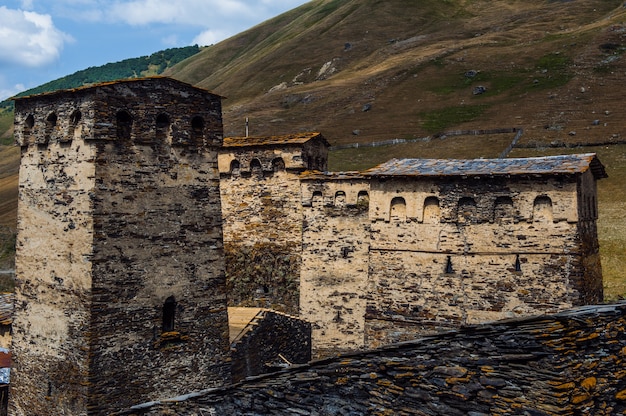 Villaggio Ushguli paesaggio con enormi montagne rocciose parete Bezengi, Shkhara sullo sfondo a Svaneti, Georgia