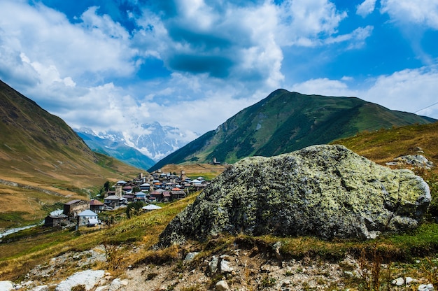 Villaggio Ushguli paesaggio con enormi montagne rocciose parete Bezengi, Shkhara sullo sfondo a Svaneti, Georgia