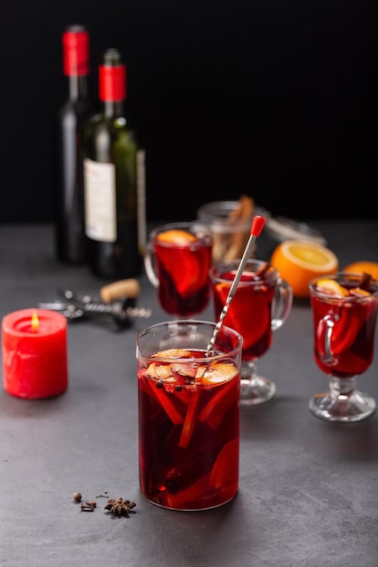 Vin brulé alcolico con frutta e spezie su uno sfondo scuro, bevanda alcolica tradizionale, Natale