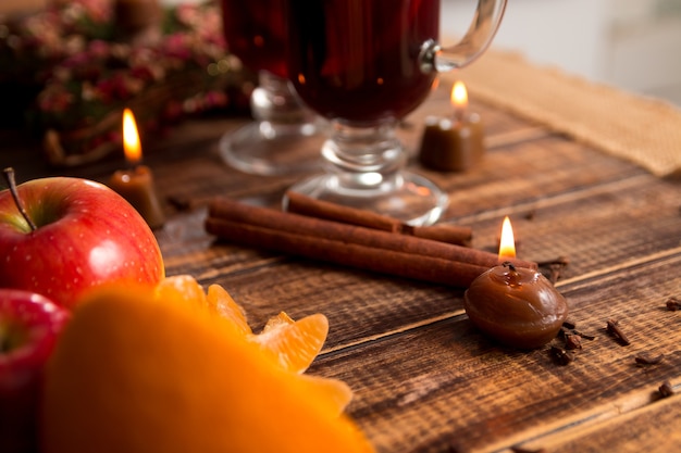 Vin brulè con frutta e spezie sulla tavola di legno