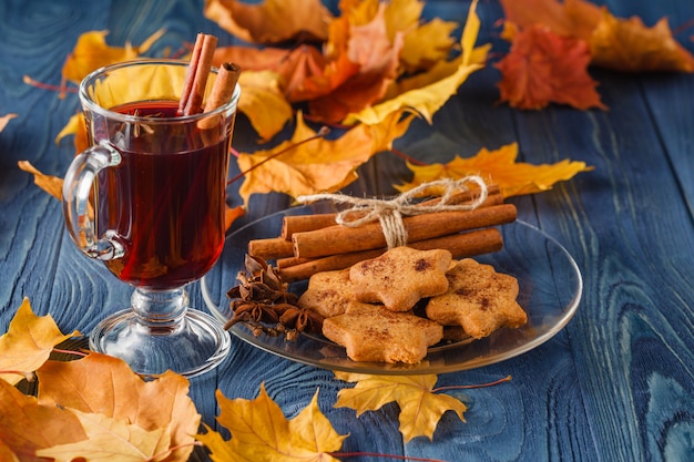 Vin brulè con spezie e decorazioni autunnali sul tavolo di legno