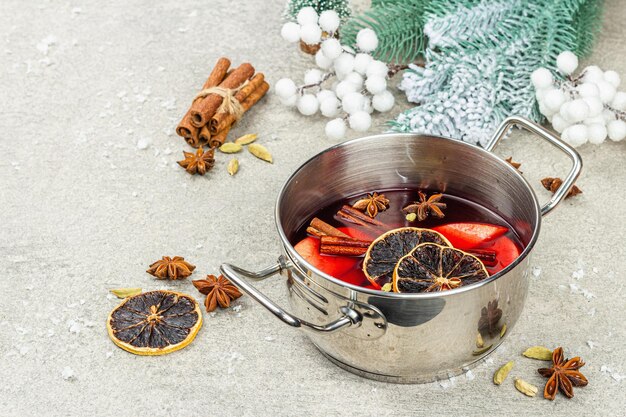 Vin brulè con spezie in una pentola con decorazioni natalizie tradizionali Bevande calde sfondo festivo