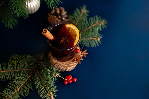 Vin brulé di Natale con stecca di cannella, arancia, anice e chiodi di garofano su sfondo blu. Vacanze invernali.