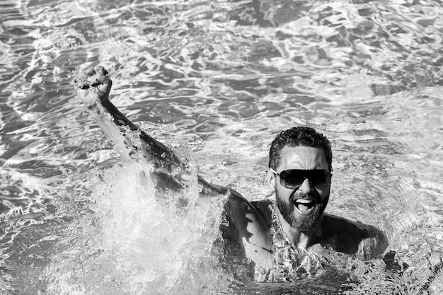 Vincitore della vita. Uomo bello in piscina. Festa in piscina. Località estiva.