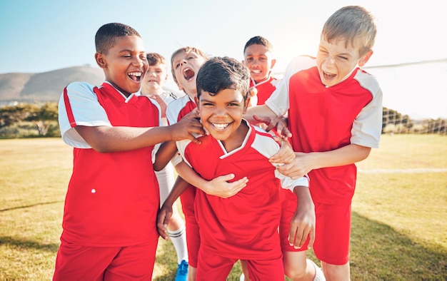 Vincitore di calcio o felice squadra di bambini per l'obiettivo di successo o la celebrazione nel gioco o nella competizione sul campo di calcio Calcio sport ragazzo o atleta bambini in allenamento allenamento lavoro di squadra esercizio o supporto