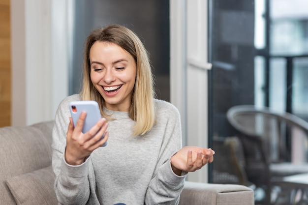 vincitrice della donna che grida sì esultando il successo guardando il cellulare