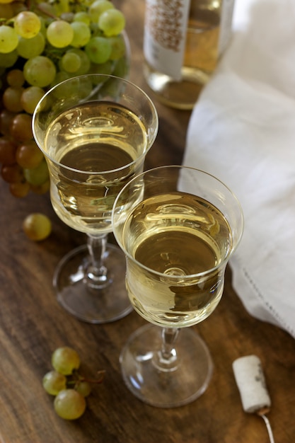 Vino bianco con calici di vetro e grappoli d'uva