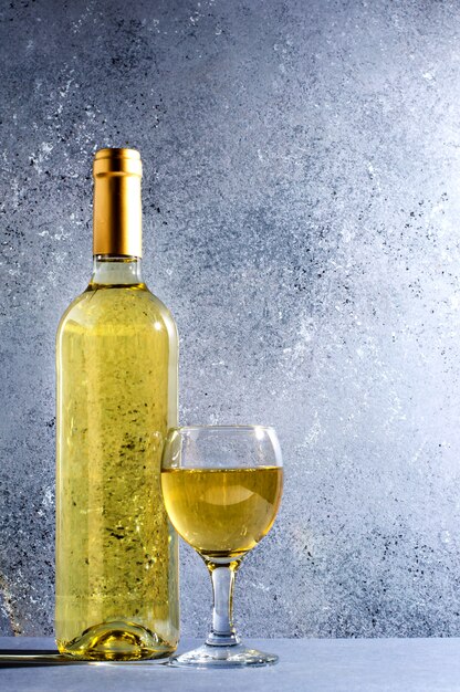 Vino bianco in bicchieri di vino di vetro, una bottiglia di vino