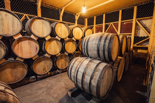 Vino d'annata o botti di rovere di legno di cognac nella cantina della cantina Invecchiamento e fermentazione di una bevanda alcolica come concetto di impresa familiare