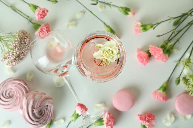 Vino, dolci e fiori sulla tavola bianca
