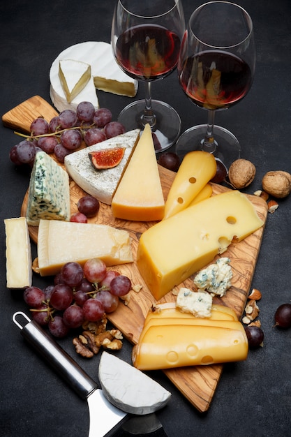 Vino e vari tipi di formaggio: parmigiano, brie, roquefort, cheddar
