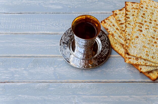 Vino kosher rosso con matzah o matza e un haggadah pasquale su uno sfondo di legno vintage presentato