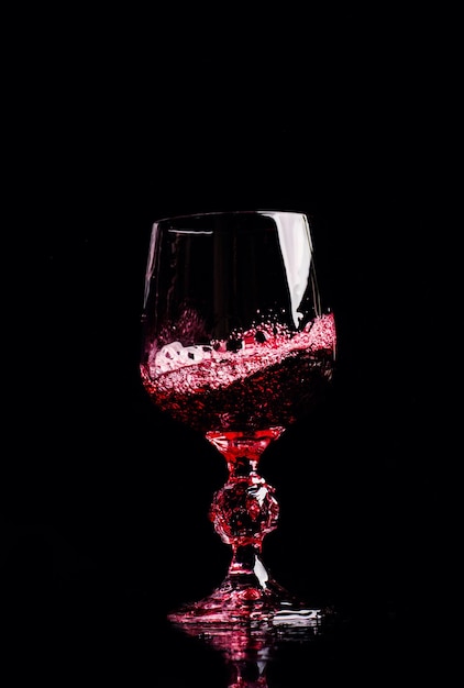 Vino rosso che versa nel bicchiere di vino