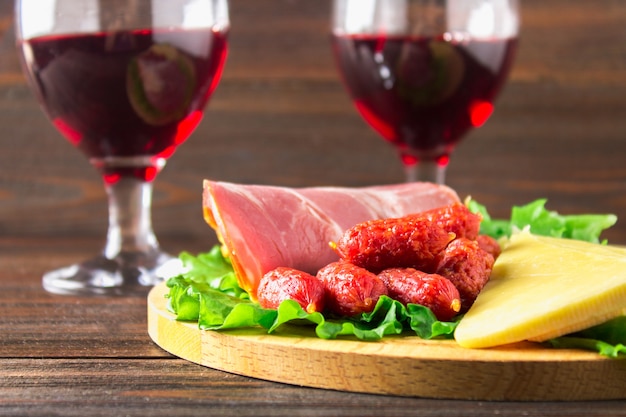 Vino rosso con assortimento di salumi sullo sfondo