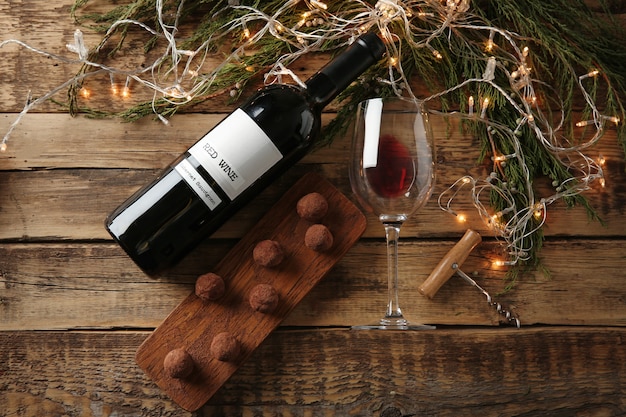 Vino rosso, dolce al cioccolato e decorazioni natalizie su tavola di legno
