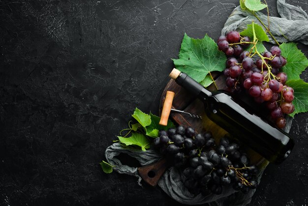 Vino rosso e uva fresca su un tavolo di pietra nera Vista dall'alto Spazio libero per il testo