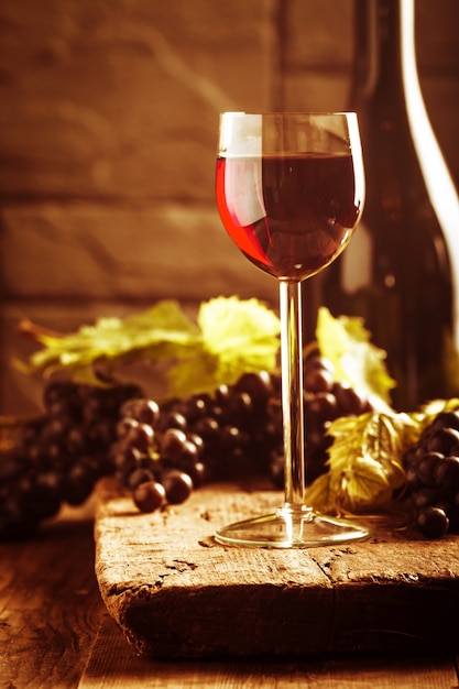 Vino rosso e uva in ambiente vintage su legno