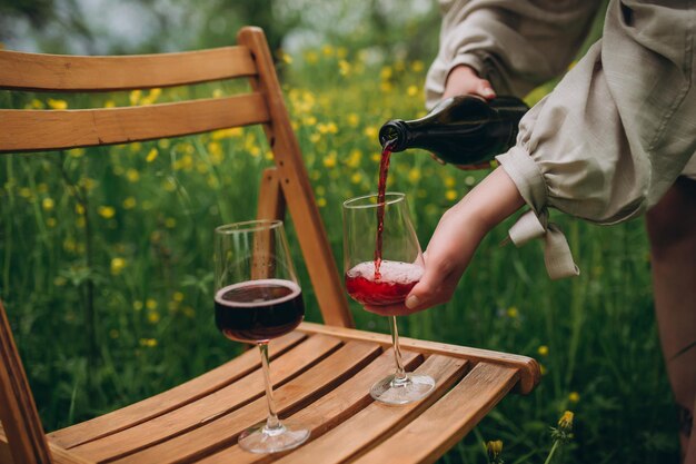 Vino rosso e vetro sulla sedia di legno del fondo