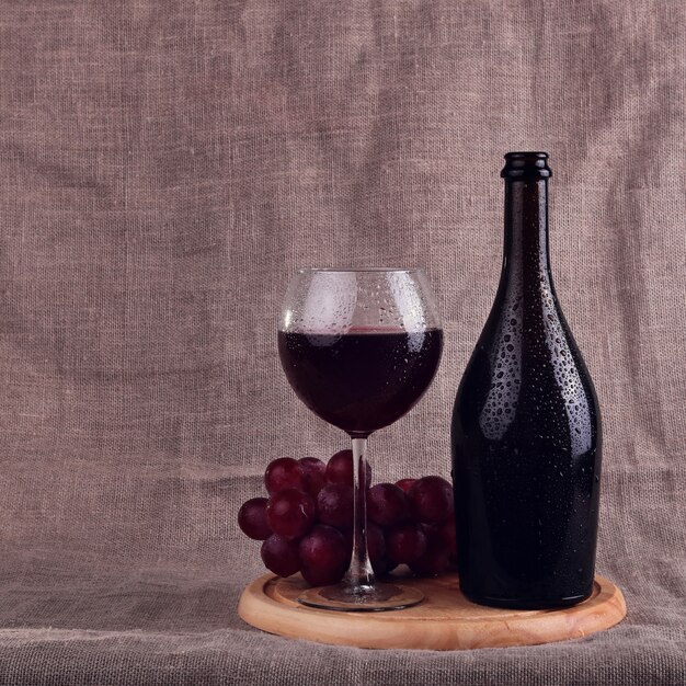 Vino rosso, formaggi e uva in un ambiente naturale.