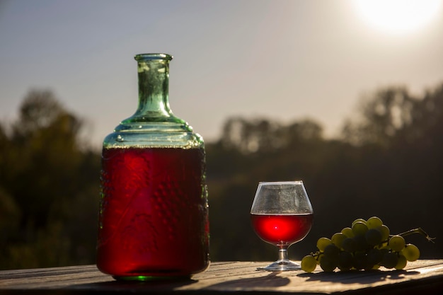 Vino rosso in un bicchiere e bottiglia Sfondo sfocato