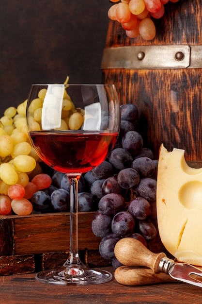 Vino, uva, formaggio e vecchia botte di legno.