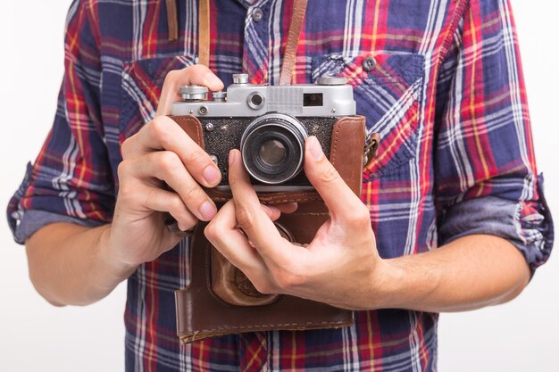 Vintage, fotografo e concetto di hobby - Chiuda in su della retro macchina fotografica nelle mani dell'uomo sopra il bianco