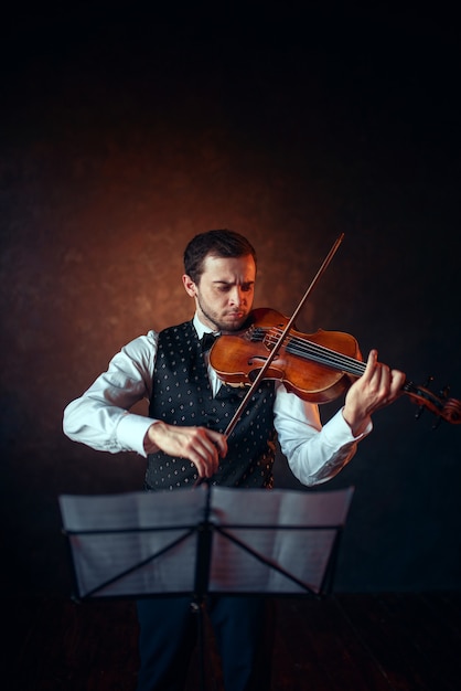 Violinista maschio che suona musica classica al violino. Uomo violinista con strumento musicale