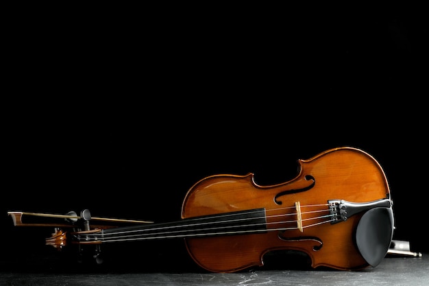 Violino classico e arco sul tavolo di pietra grigia Spazio per il testo