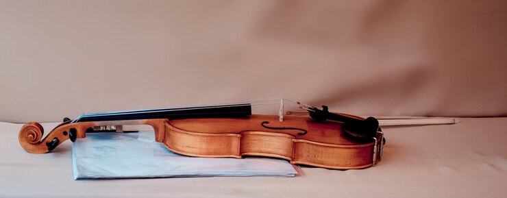 Violino con archetto e cartella blu per spartiti sul tavolo