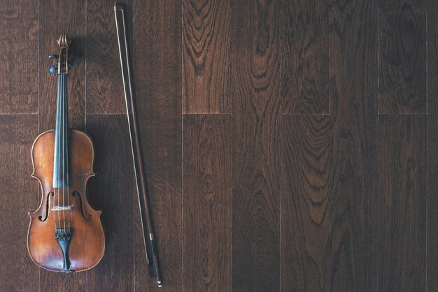 Violino con archetto su pavimento in legno