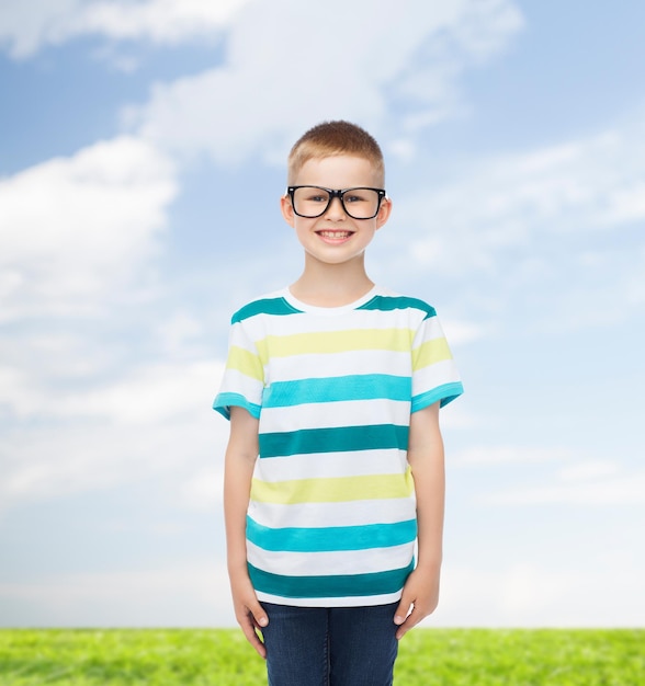 visione, educazione, natura e concetto di scuola - ragazzino sorridente con gli occhiali su sfondo naturale