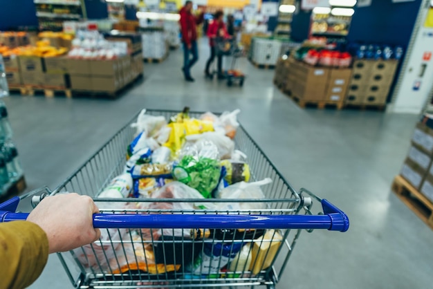 Visione in prima persona. uomo con carrello in drogheria. concetto di acquisto