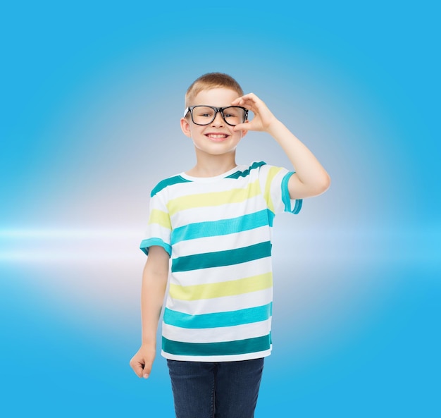 visione, istruzione e concetto di scuola - ragazzino sorridente con gli occhiali su sfondo blu con luce laser