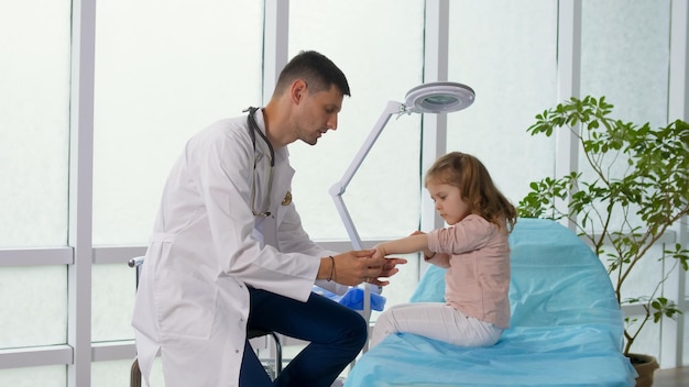 Visita medica preventiva del bambino in clinica un medico premuroso esamina la gola di un l...