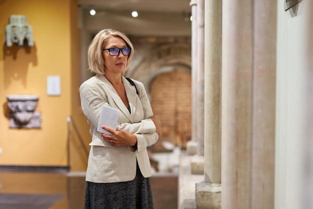 Visitatore donna matura vicino alle colonne nel museo storico historical