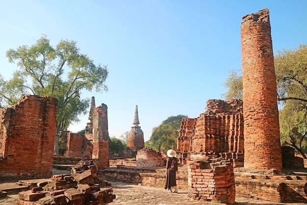 Visitatore femminile esplorando le rovine all'interno del tempio Wat Phra Si Sanphet nel parco storico di Ayutthaya Thailand