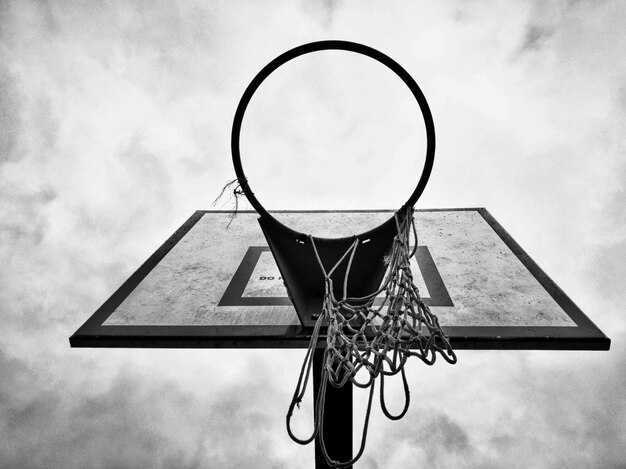 Vista a bassa angolazione del cerchio da basket contro un cielo nuvoloso