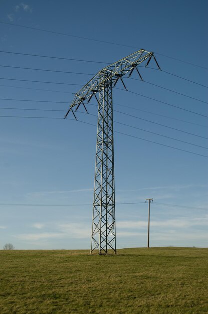 Vista a bassa angolazione del pilone elettrico sul campo contro il cielo