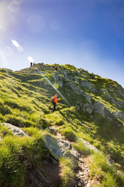Vista a bassa angolazione dell'uomo in piedi sulla montagna al picco negoiu