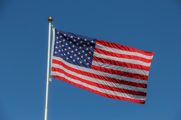 Vista a bassa angolazione della bandiera americana contro un cielo blu limpido