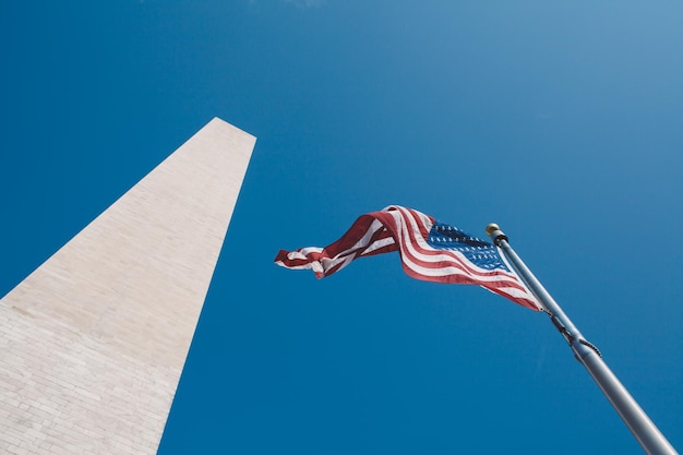 Vista a bassa angolazione della bandiera americana dal monumento a Washington contro un cielo limpido