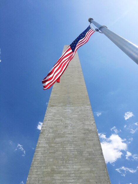 Vista a bassa angolazione della bandiera americana dal monumento contro il cielo blu