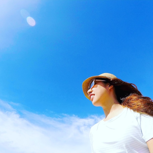 Vista a bassa angolazione della donna contro il cielo blu