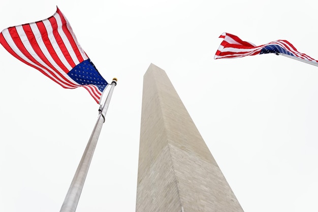 Vista a bassa angolazione delle bandiere americane dal monumento a Washington contro un cielo limpido