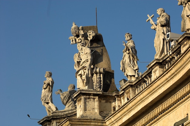 Vista a bassa angolazione delle statue della basilica di San Pietro contro un cielo blu limpido