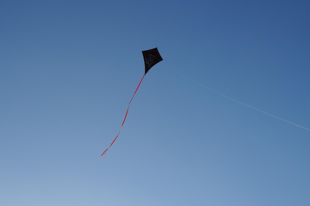 Vista a bassa angolazione di un aquilone che vola contro un cielo blu limpido