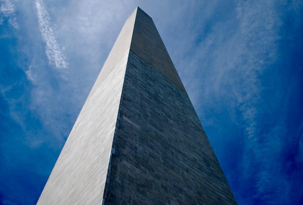 Vista a basso angolo del monumento a Washington contro un cielo blu nuvoloso in una giornata di sole