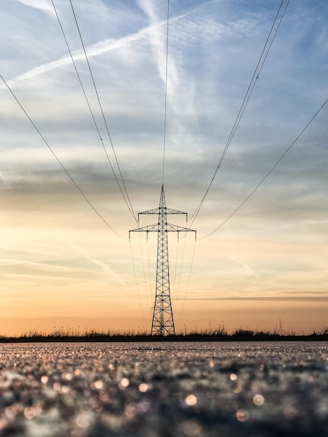 Vista a basso angolo del pilastro elettrico contro il cielo durante il tramonto